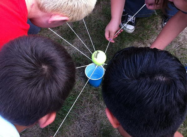 Tennis Ball Transfer Team Building Activities. This requires a large metal washer and a tennis ball for each group. The groups have to hold the strings and balance a tennis ball on the washer while walking and moving towards a plastic cup a distance away. Once the team successfully reaches the cup without dropping the ball, they have to work together to figure out how to get the ball into the cup without touching either one. 