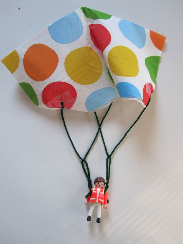 Toy Parachute Craft. Use clear tape to reinforce your napkin and punch holes for the yarn to tie through. Tie two stands and make two more knots together, then you can pop them and drop. It's so funny and you can play inside without going outside on hot summer days. 