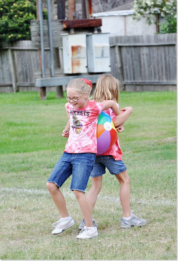 Beach Ball Race.  Kids work together to hold beach ball between their backs for the first leg of the race, then their sides, then elbows. 